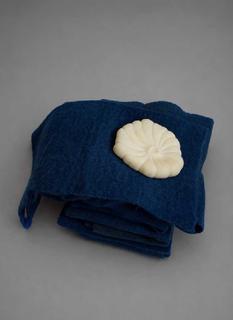 Shekine Naidi,After Twelve Leagues of DarknessPentelic White marble, felt out of sheep wool, 18 × 14 × 3 cm, 2026
